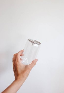 Elinde şeffaf teneke kutu var.