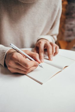 Adam deftere not yazıyor.