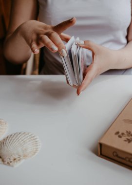 Elinde tarot kartları tutan bir kadın.
