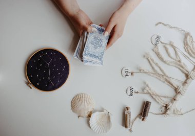 : Elinde tarot kartları tutan bir kadın.