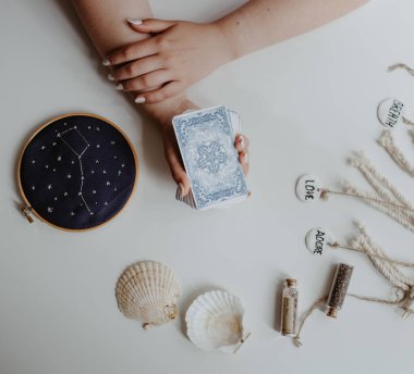 : Elinde tarot kartları tutan bir kadın.