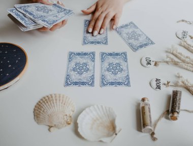 : Elinde tarot kartları tutan bir kadın.