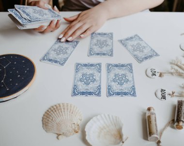 : Elinde tarot kartları tutan bir kadın.