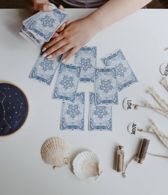 : Elinde tarot kartları tutan bir kadın.