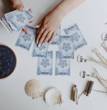 : Elinde tarot kartları tutan bir kadın.
