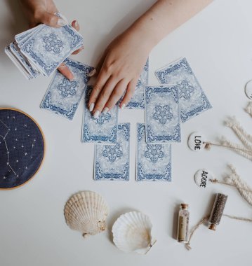 : Elinde tarot kartları tutan bir kadın.