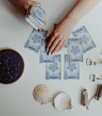 : Elinde tarot kartları tutan bir kadın.