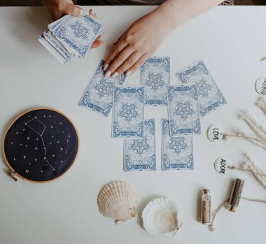 : Elinde tarot kartları tutan bir kadın.