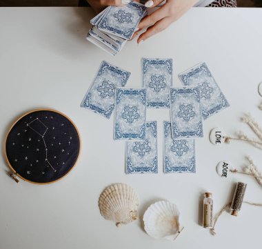 : Elinde tarot kartları tutan bir kadın.