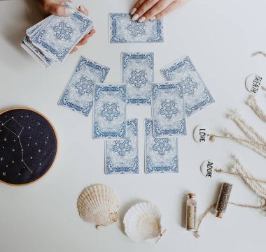 : Elinde tarot kartları tutan bir kadın.
