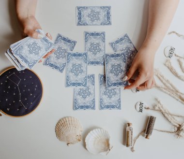 : Elinde tarot kartları tutan bir kadın.