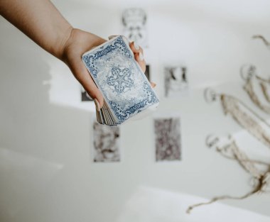 Elinde tarot kartları tutan bir kadın.