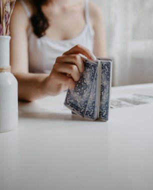 Elinde tarot kartları tutan bir kadın.