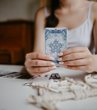 Elinde tarot kartları tutan bir kadın.