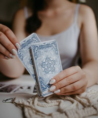Elinde tarot kartları tutan bir kadın.