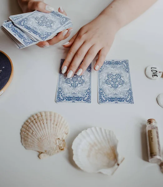 : Elinde tarot kartları tutan bir kadın.