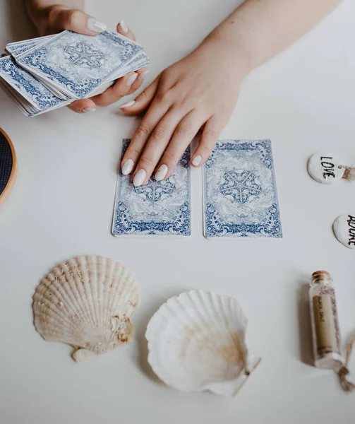 : Elinde tarot kartları tutan bir kadın.