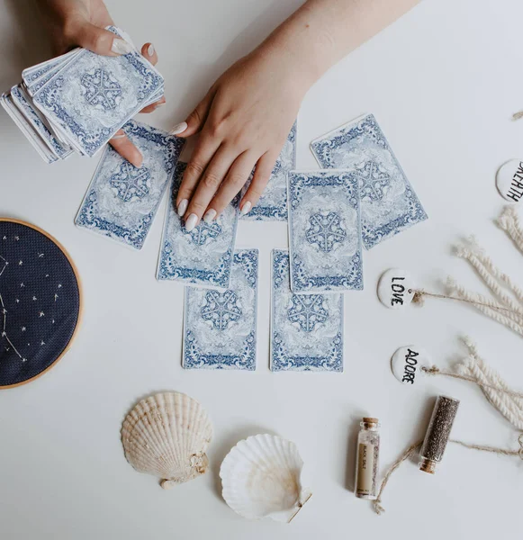 : Elinde tarot kartları tutan bir kadın.