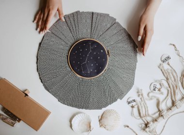 Tarot kartlı kadın masanın üstünde daire çiziyor.