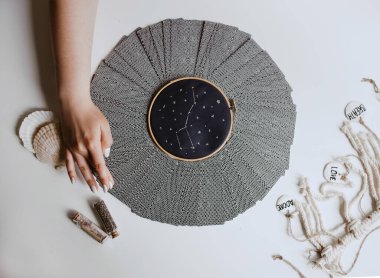 Tarot kartlı kadın masanın üstünde daire çiziyor.