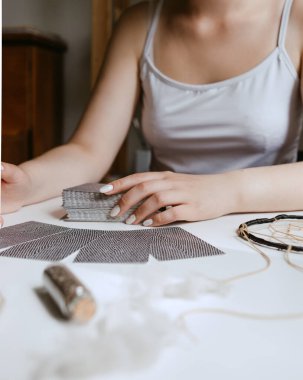 Elinde tarot kartları tutan bir kadın.