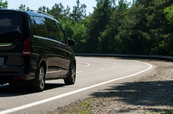 Family car on asphalt road in summer.