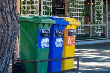 Bir şehir caddesinde cam, plastik ve kağıt için üç geri dönüşüm kutusu