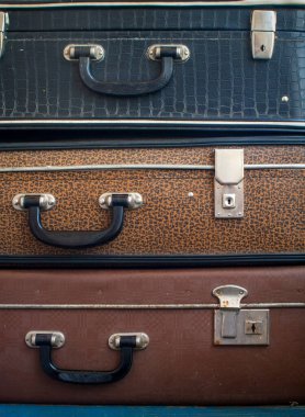 Üç eski bavul üst üste. Kapat.