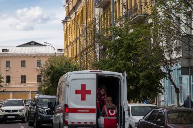 Kyiv / Ukrayna - 14 Mayıs 2020: Solunum cihazlarında çalışan iki sağlık çalışanı minibüste kırmızı haçla yol üzerindeki ambulanstan ilaç alıyor