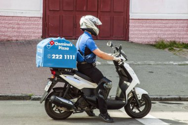 Kyiv / Ukrayna - 10 Haziran 2020: Domino 'nun ev ve ofis teslimatçısı motosikletli adam lezzetli pizzaları teslim etmek için yola çıktı