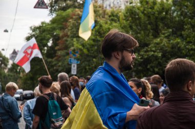 KYIV, UKRAINE - 13 AĞUSTOS 2020: Beyaz Rusya 'nın Kyiv Büyükelçiliği yakınlarındaki protestolarda Ukrayna bayrağı taşıyan aktivist Lukashenko' nun istifasını talep ediyor