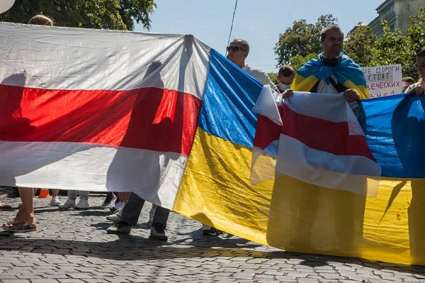 KYIV, UKRAINE - 16 AĞUSTOS 2020: Belarus 'taki Beyaz Rusya Büyükelçiliği yakınlarındaki protestolara destek olarak Belarus bayrağını taşıyan Aktivistler Alexander Lukashenko' nun istifasını talep ediyor
