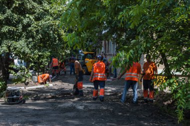 KYIV, UKRAINE - 31 Ağustos 2020: Turuncu yelekli, yaya kaldırımını tamir eden büyük bir kamu görevlisi ekibi