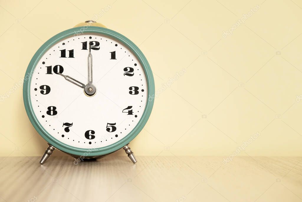 Antique analog clock with hands set at 10:00. 22:00 The alarm clock is on the table