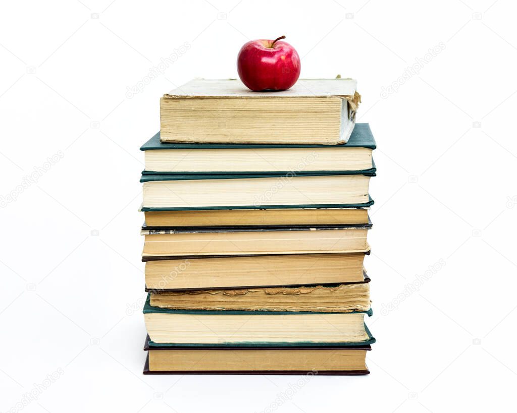 a stack of old books. A red apple lies on top. The concept of an idea came like a Newtons apple. On white background