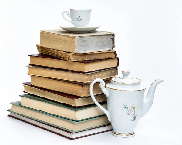 Stos starych książek i elegancki zestaw do kawy. Na białym tle. — Zdjęcie stockowe