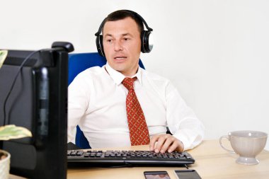 Erkek müdür evde uzaktan çalışıyor, online toplantılar yapıyor. O bir gömlek ve kravat takıyor. Evde kal ve karantinaya al. Portre, Yakın plan