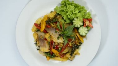  Baharatlı balık, acı biber, otlar, patlıcan ve bebek mısırı Tayland yemeği stili veya sağlıklı pişirilmiş düşük sodyumlu diyet yiyeceği ile karıştırılır.