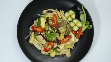 Kızarmış tavuk, zencefilli, mantarlı, biberli ve soğanlı Tayland yemeği. Sağlıklı pişirilmiş düşük sodyumlu besin. Üstü oyulmuş sebzelerle süslenmiş. 