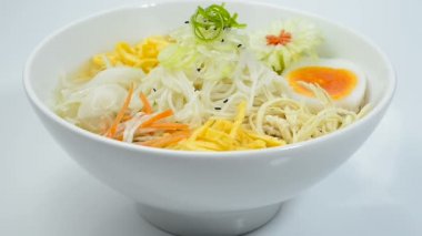 Kore Soğuk Erişte Çorbası Naengmyeon geleneksel Kore Yemeği Popüler Yaz Yemeği oymalı Pırasa çiçek biçimli yan bakış açısıyla sebze servis etti.