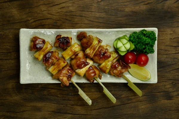 焼き鳥グリルチキンとネギバンチ玉ねぎ串日本料理のフュージョンスタイル完璧なバーベキューおいしい簡単に料理は アジアのトップビューで人気のある彫刻キュウリの花 パセリ トマトを飾る — ストック写真