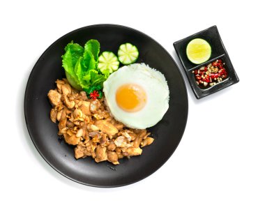 Kızarmış tavuklu sarımsaklı pilav üzerine kızarmış yumurta oyulmuş sebze biberli balık sosu Tayland usulü üst görünüm