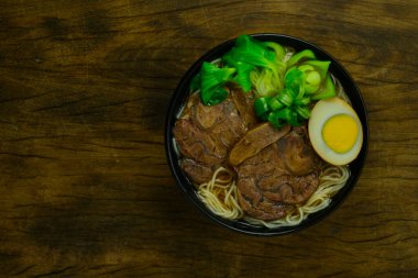 Çin Haşlanmış Biftek Eriştesi ve Biftek Bacak Dilimi Çin soslu yumurta Çin Çorbası stili bok çukulatalı lahana ve taze soğanlı leziz Asya Gıda Füzyonu üst görünümü.