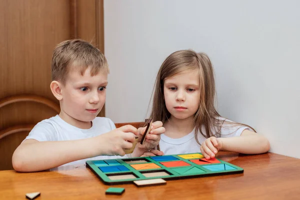 Ένα αγόρι και ένα κορίτσι της Ευρωπαϊκής εμφάνιση σε light clothng καθίσει και να παίξει ένα επιτραπέζιο παιχνίδι — Φωτογραφία Αρχείου