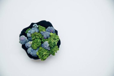 Karnabahar, beyaz arka planda izole edilmiş siyah bir plakada yatar..