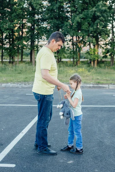 Papá ayuda a su hija a ponerse su mochila — Foto de Stock