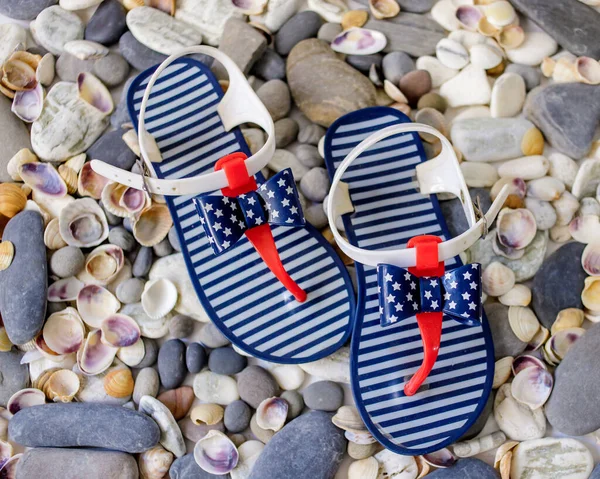Shale shoes with the image of the American flag lie on the shore Royalty Free Stock Images