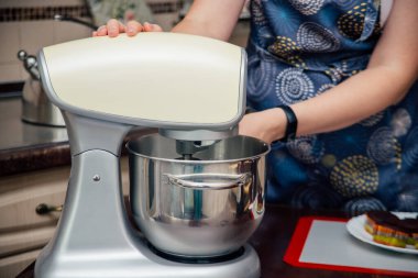 Kadın elleri karıştırıcıdan bir kase tutar.