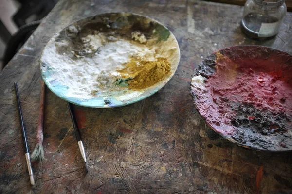 Dishes with colored powders on the painter's table