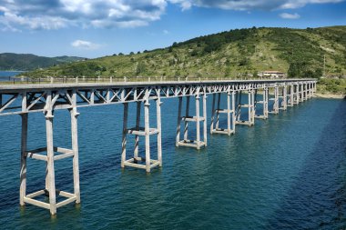 Nehrin üzerinde köprüsü olan dağ manzarası